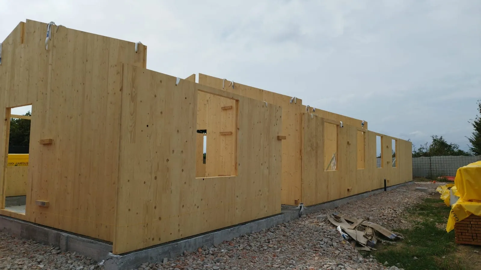 Casa in legno moderna con facciata naturale e grandi vetrate, nella campagna veneta.